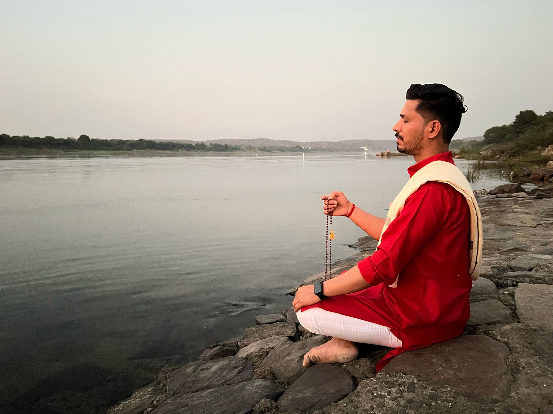 A person seated in quiet meditation practice outdoors at sunrise, evoking the calm of a mindful yoga and meditation practice